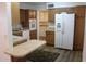 A well-lit kitchen boasting wooden cabinets, modern appliances, and a practical breakfast bar at 235 N 61St Pl, Mesa, AZ 85205