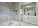 Modern bathroom with gray tile shower, soaking tub, and a large vanity with ample storage at 24066 N 90Th Way, Scottsdale, AZ 85255