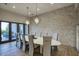 Elegant dining room with modern lighting, a large table with seating for ten, and access to patio at 24066 N 90Th Way, Scottsdale, AZ 85255