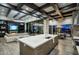 A modern kitchen and living room featuring a marble island, designer lighting, and open floor plan at 24066 N 90Th Way, Scottsdale, AZ 85255