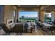 Covered outdoor living space with fireplace, comfortable seating, and views of the desert landscape at 24066 N 90Th Way, Scottsdale, AZ 85255