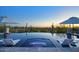 Relaxing infinity pool with lounge chairs, umbrellas, and desert views, perfect for unwinding and enjoying the outdoors at 24066 N 90Th Way, Scottsdale, AZ 85255