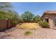 The spacious backyard features desert landscaping with established trees and a block wall at 25667 W Primrose Ln, Buckeye, AZ 85326