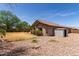 Backyard featuring desert landscaping, a storage shed, and lush green trees beyond the perimeter fence at 25667 W Primrose Ln, Buckeye, AZ 85326