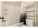 A clean white bathroom features a shower-tub combo and a metal storage rack at 25667 W Primrose Ln, Buckeye, AZ 85326