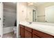 Bathroom features wood vanity, sink, mirror, and a shower-tub combo at 25667 W Primrose Ln, Buckeye, AZ 85326