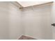 Walk-in closet featuring natural wood shelving and tile flooring at 25667 W Primrose Ln, Buckeye, AZ 85326