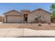 Charming single-story home with a brick-paved driveway and beautiful desert landscaping at 25667 W Primrose Ln, Buckeye, AZ 85326