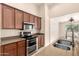 Modern kitchen features wood cabinets, stainless steel appliances, and granite countertops at 25667 W Primrose Ln, Buckeye, AZ 85326