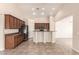 Well-equipped kitchen with dark cabinets, stainless steel appliances, and breakfast bar seating at 25667 W Primrose Ln, Buckeye, AZ 85326