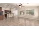 Open concept living room with breakfast bar, tile flooring, ceiling fan, and backyard view at 25667 W Primrose Ln, Buckeye, AZ 85326
