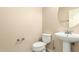 Cozy powder room features a pedestal sink and a white toilet at 25667 W Primrose Ln, Buckeye, AZ 85326