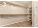 Large walk-in closet featuring built-in shelves and rod for clothes storage at 25667 W Primrose Ln, Buckeye, AZ 85326