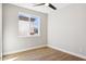 Well lit bedroom with wood-look floors, ceiling fan, and neutral paint at 25894 W White Feather Ln, Wittmann, AZ 85361