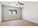 Spacious bedroom with wood-look floors, ceiling fan, and large window at 25894 W White Feather Ln, Wittmann, AZ 85361