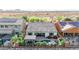 Aerial view of the backyard featuring a patio, pool, lush landscaping, and neighboring rooftops with solar panels at 31107 N 27Th Ave, Phoenix, AZ 85085