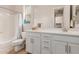 Bright bathroom featuring a double vanity, shower with tub, and an adjacent space at 31107 N 27Th Ave, Phoenix, AZ 85085