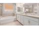 This bright bathroom features a soaking tub and double vanity with tile accents at 31107 N 27Th Ave, Phoenix, AZ 85085