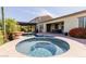 Inviting backyard pool and spa with a covered patio, lush greenery, and desert landscaping at 31107 N 27Th Ave, Phoenix, AZ 85085