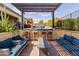 Outdoor living space featuring a lounge area, outdoor bar, pergola and serene desert landscaping at 31107 N 27Th Ave, Phoenix, AZ 85085