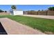 Expansive backyard with green grass, detached garage, and a brick patio, perfect for outdoor entertaining at 3310 W Sweetwater Ave, Phoenix, AZ 85029