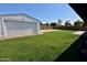 Spacious backyard featuring green lawn, detached garage, and brick-paved area, perfect for outdoor activities at 3310 W Sweetwater Ave, Phoenix, AZ 85029