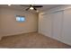 Neutral bedroom features carpet, closet with sliding doors, window and ceiling fan at 3310 W Sweetwater Ave, Phoenix, AZ 85029