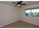 This cozy bedroom is carpeted with a ceiling fan and natural light from the window at 3310 W Sweetwater Ave, Phoenix, AZ 85029