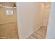 Bright bedroom with neutral carpet, a ceiling fan, and a well-lit hallway to the door at 3310 W Sweetwater Ave, Phoenix, AZ 85029