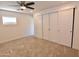 Spacious bedroom featuring a ceiling fan, a large window, and a closet with white sliding doors at 3310 W Sweetwater Ave, Phoenix, AZ 85029