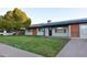 Inviting single-story home boasts fresh grass,solar panels, and a brick accent wall at 3310 W Sweetwater Ave, Phoenix, AZ 85029
