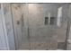 Tile shower with a pebble floor, integrated corner shelves, and a built-in bench at 3310 W Sweetwater Ave, Phoenix, AZ 85029
