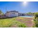 A spacious backyard featuring a refreshing pool, covered patio, and grassy area for outdoor enjoyment at 3408 W Carol Ave, Phoenix, AZ 85051
