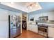 Well-lit kitchen with stainless steel appliances, white cabinetry, and convenient access to the laundry area at 3408 W Carol Ave, Phoenix, AZ 85051