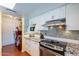 Modern kitchen with laundry area, granite countertops, stainless steel appliances, and tiled backsplash at 3408 W Carol Ave, Phoenix, AZ 85051