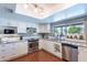 Bright kitchen with tiled backsplash, wood floors, stainless steel appliances, and white cabinetry at 3408 W Carol Ave, Phoenix, AZ 85051