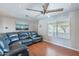 Inviting living room featuring modern ceiling fan, hardwood floors, and lots of natural light at 3408 W Carol Ave, Phoenix, AZ 85051