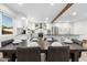 Bright dining room with a large wooden table set for a meal, flowing into a modern kitchen at 3615 E Charter Oak Rd, Phoenix, AZ 85032