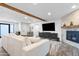 Spacious living room with fireplace, large television, modern furniture and wood beam at 3615 E Charter Oak Rd, Phoenix, AZ 85032
