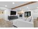 Cozy living room with a stone fireplace, modern TV, and comfortable white sofa at 3615 E Charter Oak Rd, Phoenix, AZ 85032