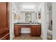 Well-lit bathroom vanity with wooden cabinets, spacious counter, and tiled flooring at 3825 E Camelback Rd # 117, Phoenix, AZ 85018