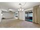 Spacious living room featuring neutral carpet, a ceiling fan, modern lighting, and sliding glass doors at 400 N Jay N St, Chandler, AZ 85225