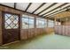 Enclosed sunroom featuring wood paneling, carpeted floor, and multiple windows at 400 N Jay N St, Chandler, AZ 85225