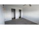 A simple bedroom with gray carpet and two closet doors provides ample storage space at 4008 W El Caminito Dr, Phoenix, AZ 85051