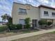 Beige stucco townhome showcasing lovely shrubbery and metal security doors at 4614 N 19 Ave, Phoenix, AZ 85015