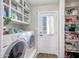 Clean and functional laundry room with washer, dryer, shelving, and exterior access at 4808 W Shaw Butte Dr, Glendale, AZ 85304