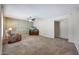 Living room with stone accent wall, carpet, and ceiling fan at 4808 W Shaw Butte Dr, Glendale, AZ 85304