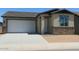 Charming single-story home featuring a two-car garage, stone accents, and neutral stucco exterior at 5633 S 253Rd Ave, Buckeye, AZ 85326