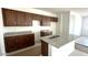 An unfinished kitchen features dark brown cabinets, granite countertops, and a center island with a sink at 5633 S 253Rd Ave, Buckeye, AZ 85326