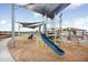 Playground with climbing structures and a slide, covered by sun shades and surrounded by woodchips for safety at 5633 S 253Rd Ave, Buckeye, AZ 85326